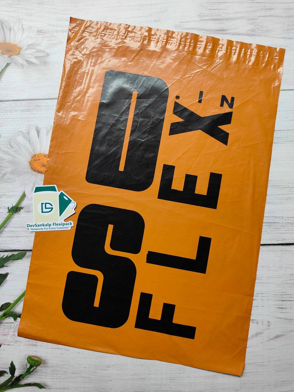 Customized printed orange polybag with POD, featuring bold black branding. Durable poly mailer ideal for secure shipping and brand visibility.